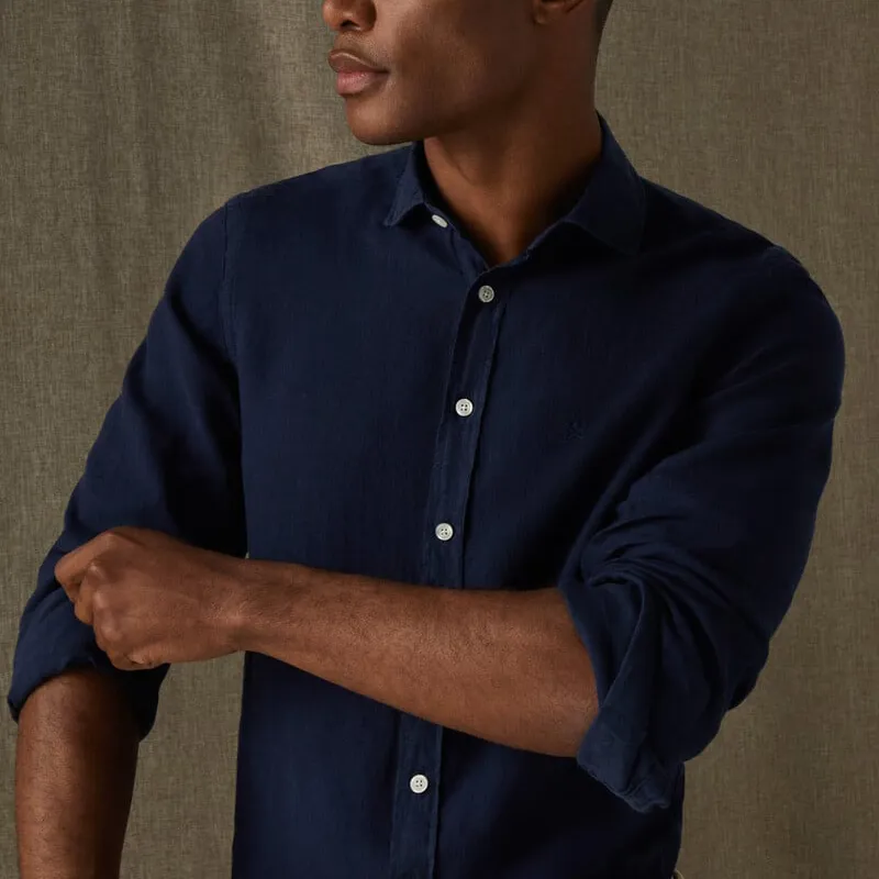 Man wearing a navy shirt rolling the sleeves up