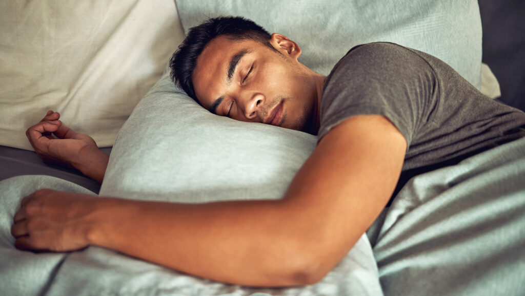 Man sleeping cuddling a pillow