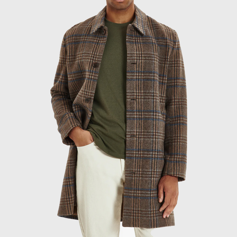 Man wearing check coat with hand in pocket