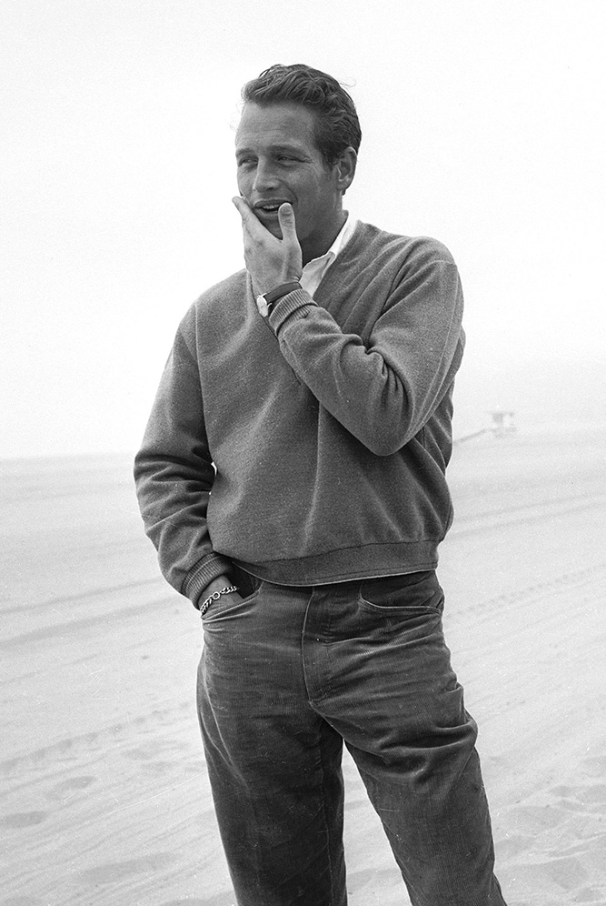Paul Newman wearing a pullover and trousers at the beach