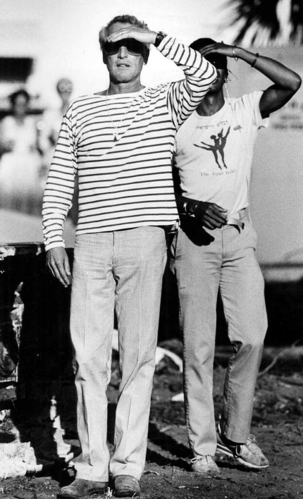 Paul Newman wearing a striped long sleeved t-shirt looking into the distance