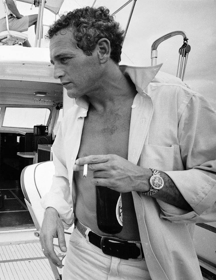Paul Newman drinking a beer with his shirt undone