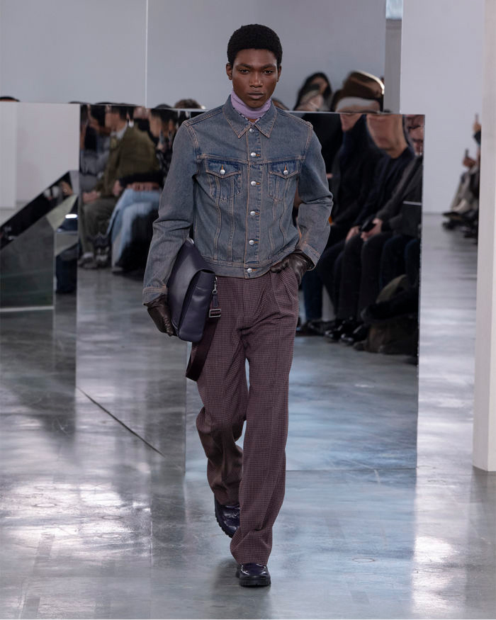 Model walking in denim jacket and purple trousers