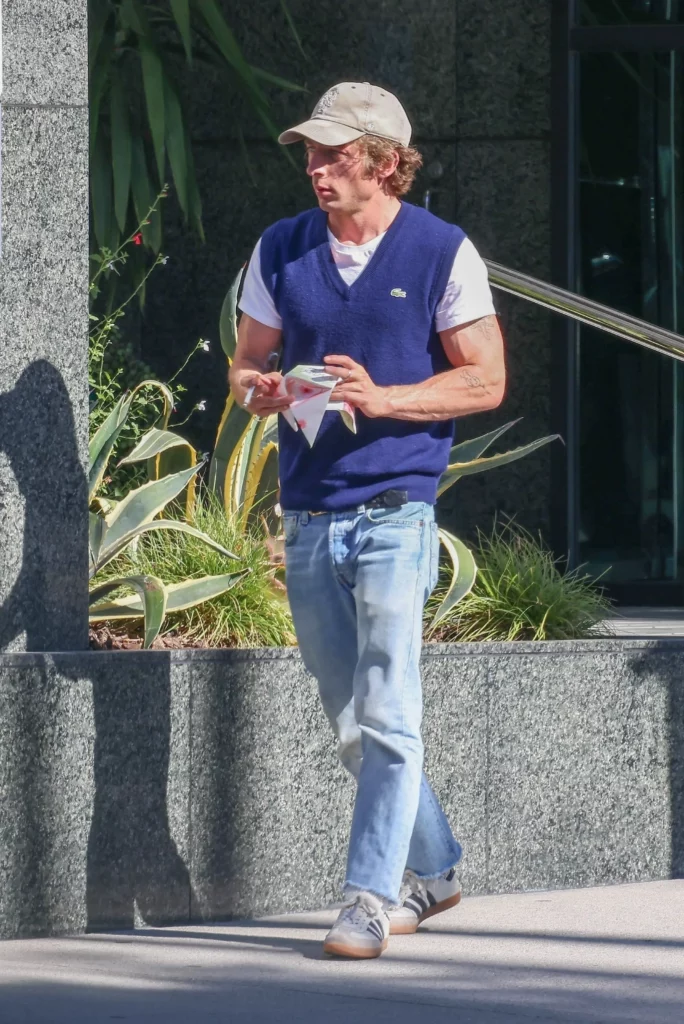 Man walking down street in blue vest