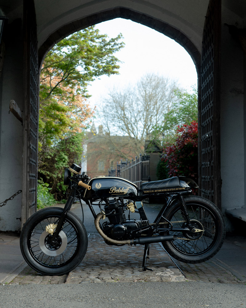 A motorcycle parked in front of an archway on the pavement