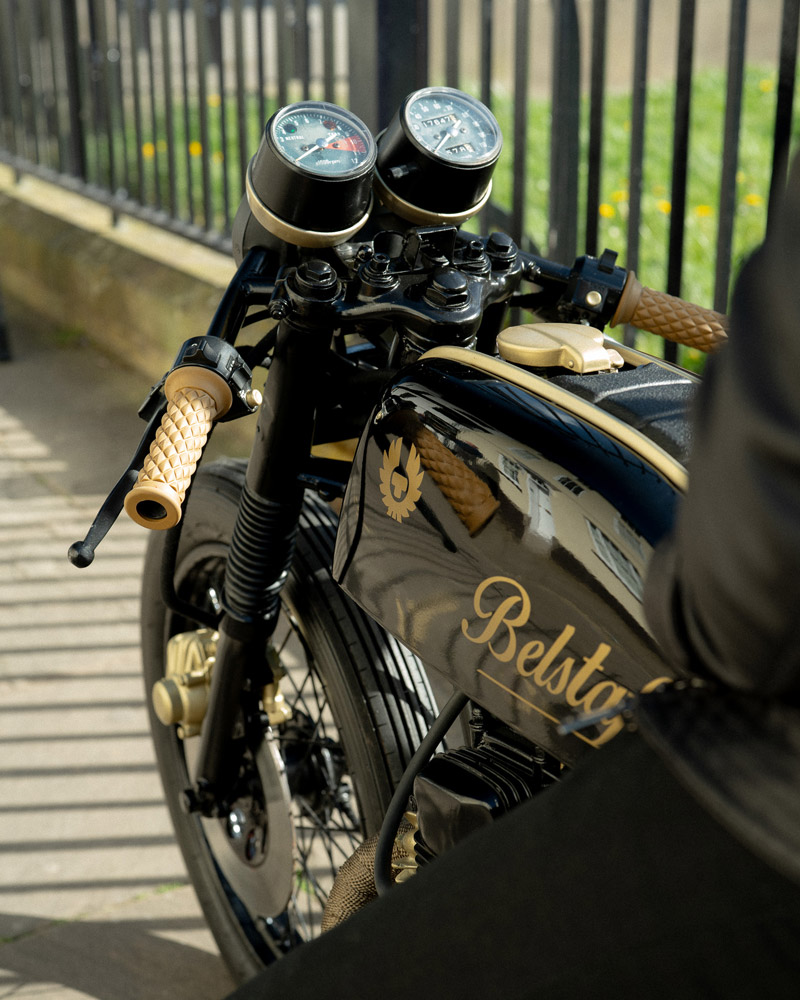 A closeup image of the dashboard of a motorcycle next to a fence