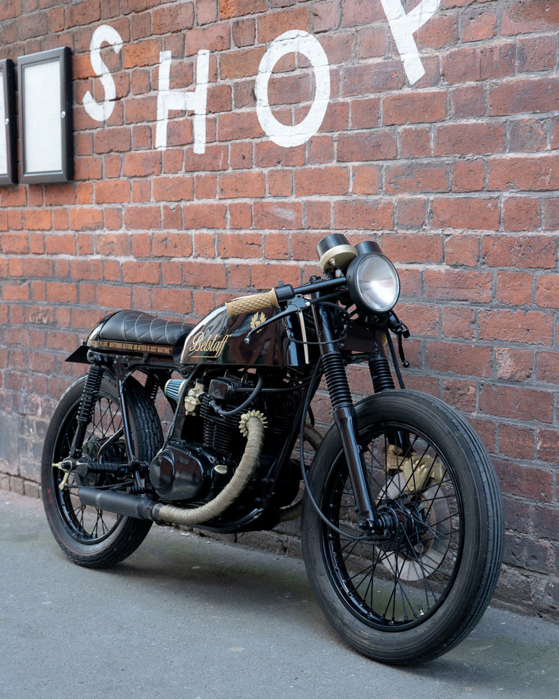 A motorcycle parked next to a wall on the pavement