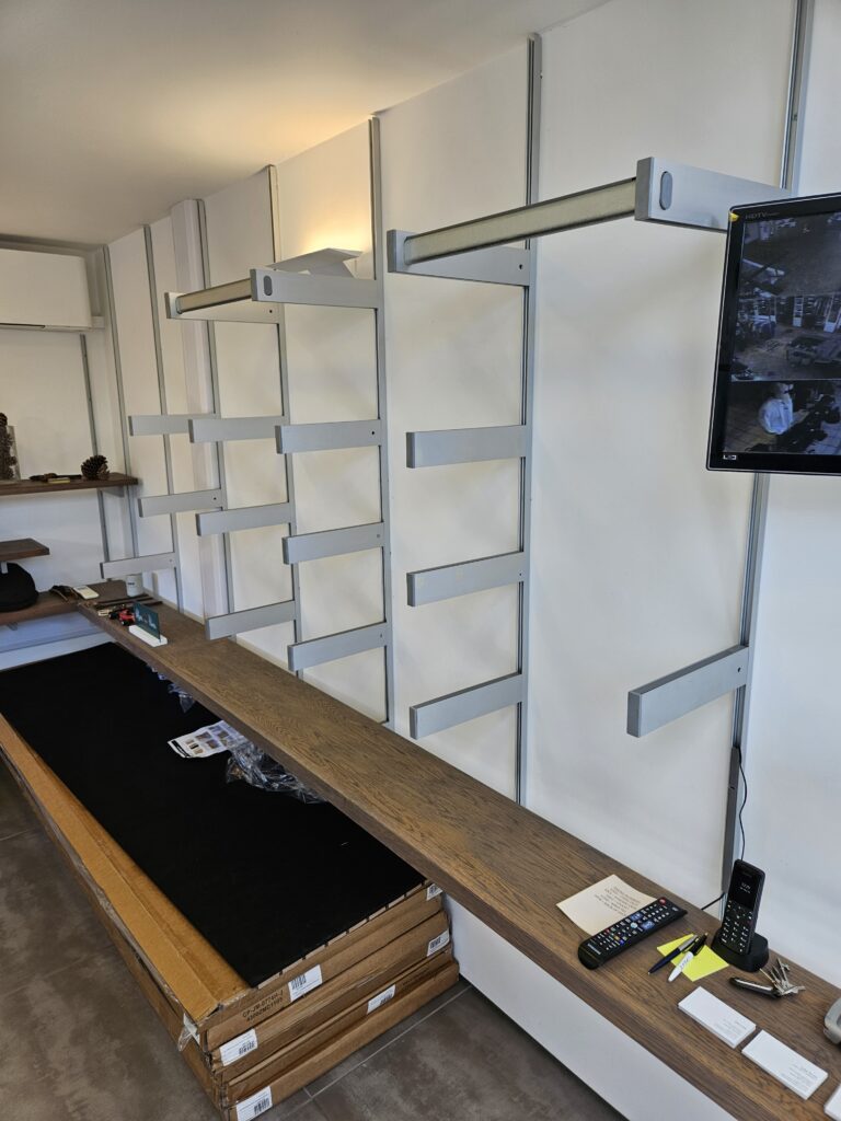 An image of a white wall with silver shelving on.