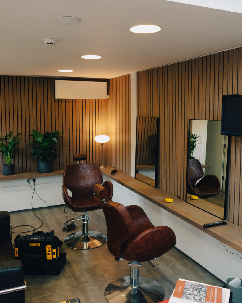 Image of barbershop chairs and mirrors propped up on a wall.