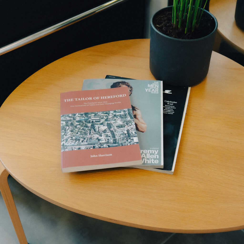 Magazines placed on a table next to a plant pot.