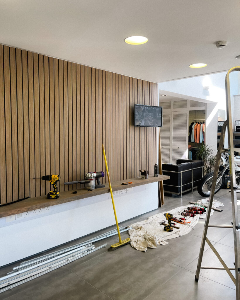 Image of wall and shelves with power tools and ladder.