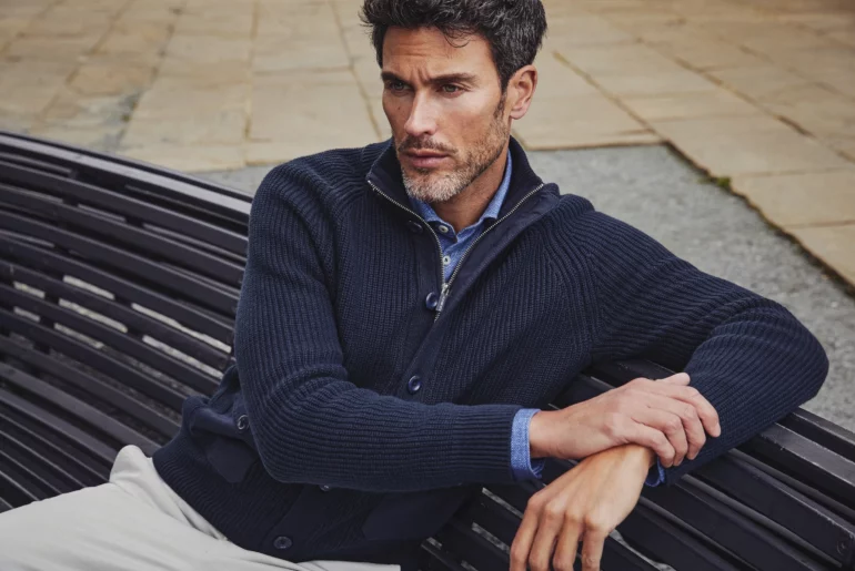 Man sat on a bench and holding his arm