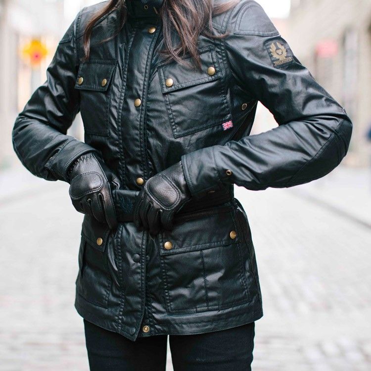 A woman fastening the belt on her jacket