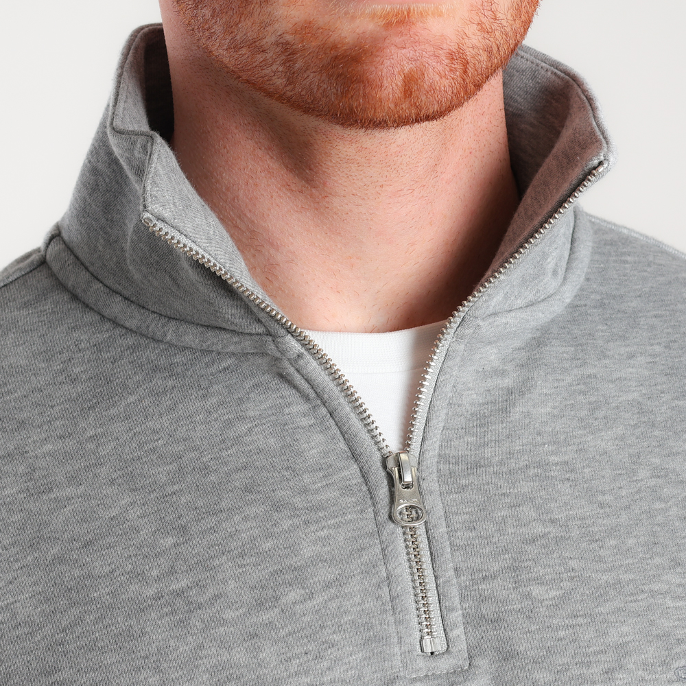 A closeup image of the zip on a grey sweatshirt.