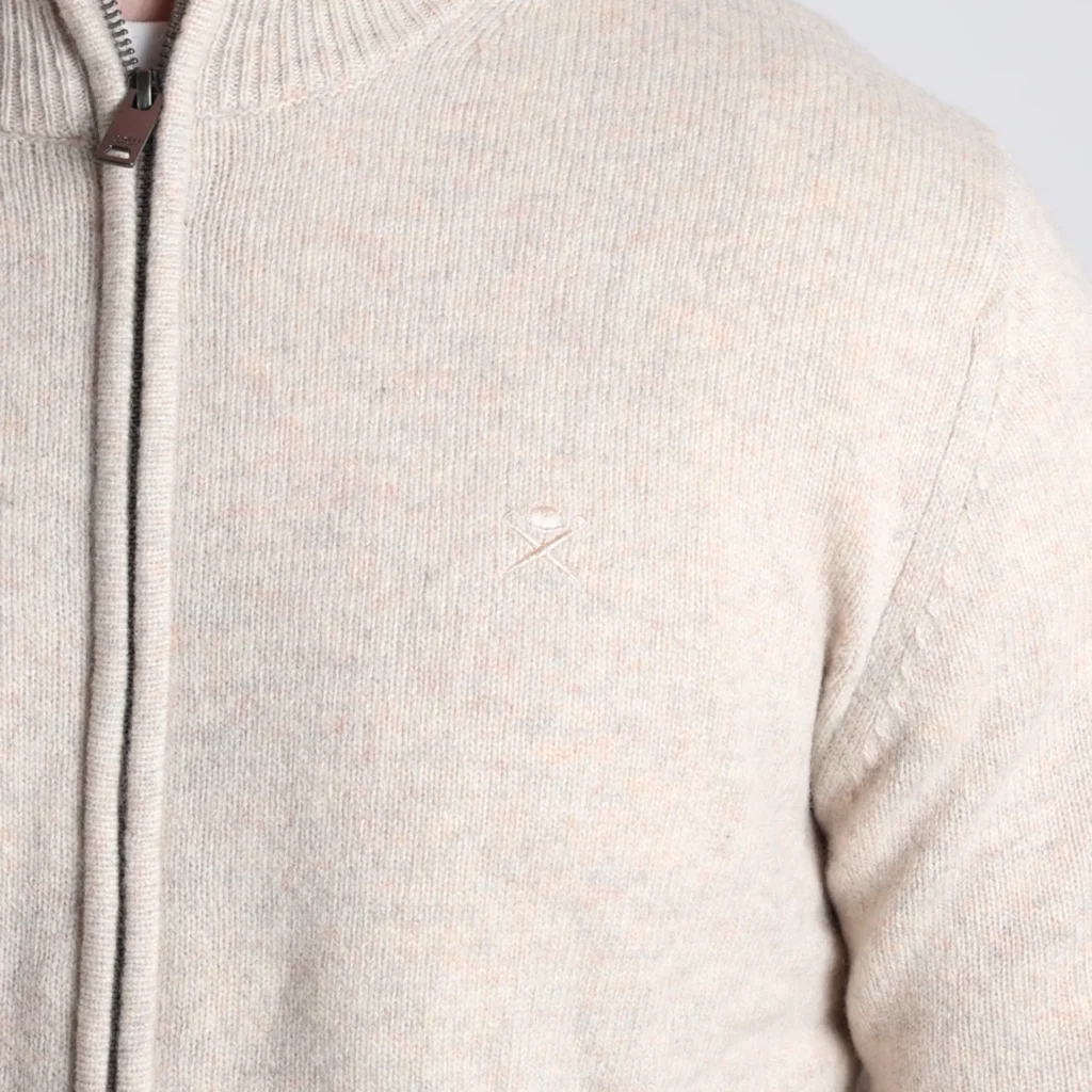 A closeup image of a brand logo on the chest of a cardigan.