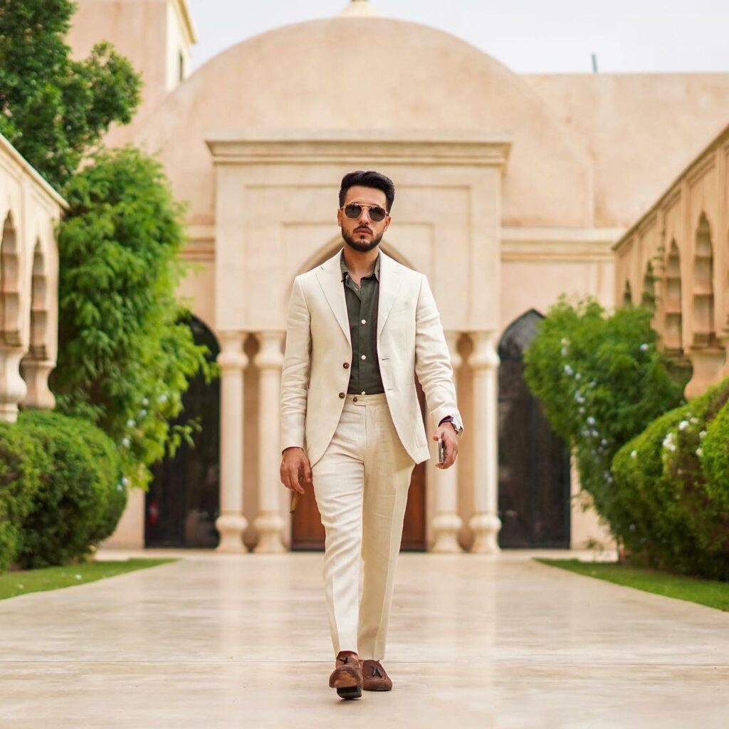 A man walking towards the camera wearing a linen suit